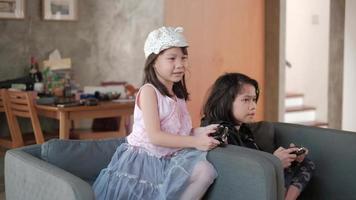 dos chicas asiáticas en ropa casual juegan divertidos videojuegos consola.