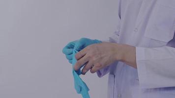 porter des gants. le médecin de sexe masculin porte un gant pour les mains en caoutchouc nitrile bleu. video