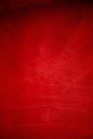 Dark red matte background of suede fabric, closeup. Velvet texture of seamless wine leather. photo