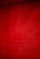 Dark red matte background of suede fabric, closeup. Velvet texture of seamless wine leather. photo