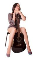 Beautiful young girl sitting with guitar photo