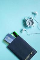 Summer vacation concept. Flatlay travel accessories on a blue background. Passport, credit cards, headphones. photo