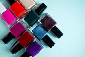 Palette of bright nail polishes on blue background. photo