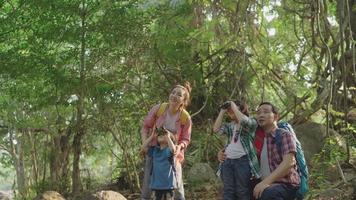 pais de família levam dois filhos para fazer caminhadas com binóculos para fins educativos e aprendem sobre a natureza nas férias no centro de estudos da natureza. video