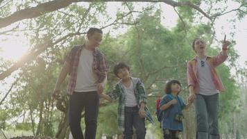 Asian father and mother teach two sons Hiking using binoculars For education Learn nature on vacation at the nature study center. video