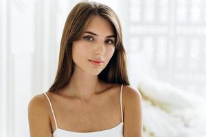 Portrait of the pretty young caucasian woman seducing by her appearance while posing at her bathroom. Woman face and healthy hair concept photo