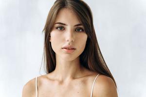 Portrait of young caucasian tender woman with perfect and soft skin. She is looking at camera dreamily. Isolated background photo