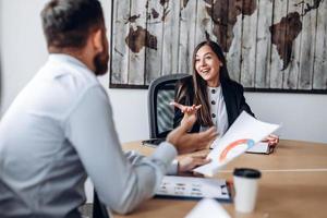 Atractiva empresaria en la oficina de negocios discutiendo activamente el proyecto con su colega foto