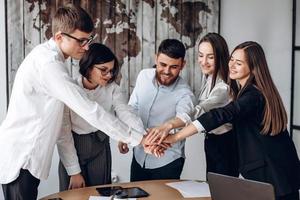 Young business people putting their hands together. Stack of hands. Unity and teamwork concept. photo