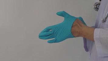 usando guantes. El médico masculino usa guantes de manos de nitrilo de goma azul. video