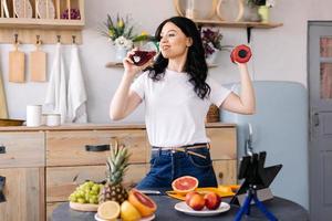 Young, beautiful girl drinks a delicious fruit smoothie photo