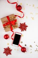 hermosas decoraciones navideñas y smarphone sobre fondo blanco. foto