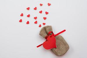 On a white background lies a small bag with a gift for Valentine's Day photo