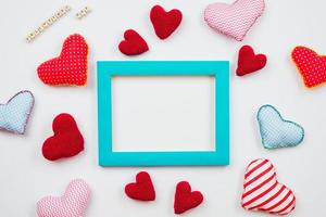 Multicolored hearts and a frame of blue are spread on a white background. Theme for Valentine's Day. place for text