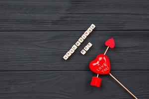 Valentines day. Heart pierced by arrow on wooden table background photo