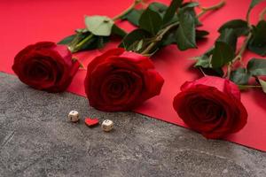 On a gray-red background there are red roses and cubes with letters laid out, the phrase I love you photo