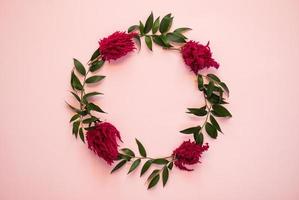Arch of fresh flowers lie on a pink background - Image photo