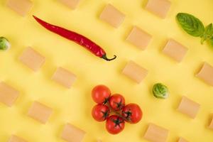 Delicious ingredients for an Italian dish arranged on a yellow background. photo