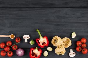 Top view on wooden table with italian products peppers, tomatoes, pasta. Copy space for text. photo