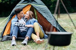 A lovely couple sitting in the tent outdoor and looking each other photo