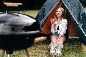 Girl sitting in the tent holding a fresh vegetable in her hands and smiling photo