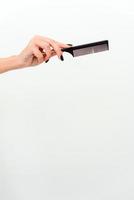 Woman hands with hair comb isolated on a white background photo