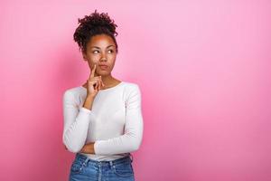 Studio portrait of a thinking pose girl touching herself face by index finger- Image photo