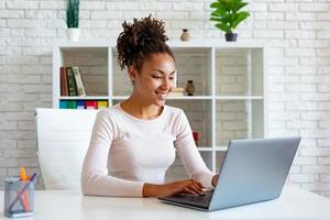 Woman working on laptop in the office looking at the screen and typing . - Image photo