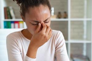 Chronic headache concept, young exhausted woman suffers from migraine ,front view photo