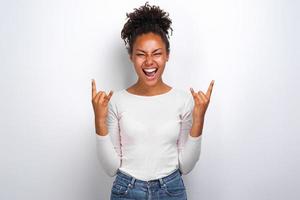 Excited woman hands up with rock gesture in studio. Concept gesture - Image photo