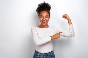 Funny girl pointing to an herself biceps smiling looking at the camera photo