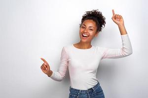 mujer mulata divertida bailando y riendo, manos arriba. fiesta de concepto foto