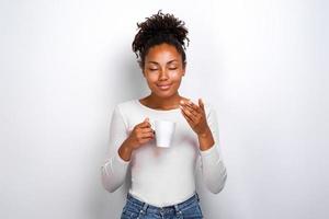 Pleased cute mulatto girl inhales the aroma of coffee