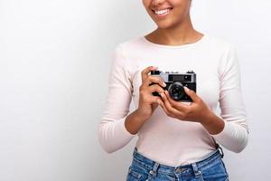 Cropping studio image of a traveler girl holding photo camera in her hands - Image