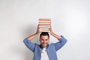 Funny happy young man holding books on his head. Back to school- Image photo