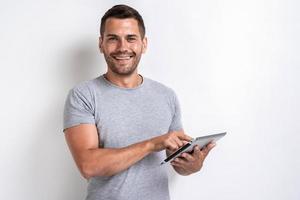 Happy man standing with ipad looking at the camera- Image photo