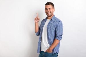 Man pointing his index finger up while standing in the studio . - Image photo