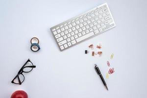 white desk with astationery and other objects on it photo