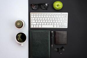 escritorio blanco y negro con acactus, una taza de café y un material de oficina foto