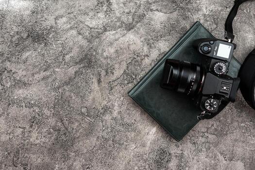 Top view photocamera and a notebook lying on a plaster background photo