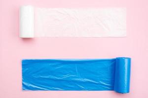 New white and blue garbage bags on a pink background. photo