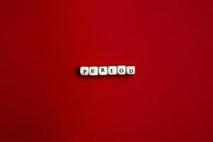 The word Period is laid out of dice on a red background photo