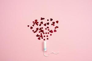 Tampon with hearts on a pink background. photo