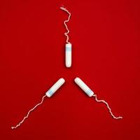 Hygienic tampons on red background, women's health, figure with tampons. photo