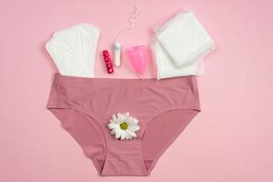 Underwear with protective equipment for critical days on a pink background. photo