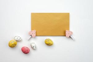 tarjeta de felicitación en blanco y huevos de pascua sobre un fondo blanco. foto
