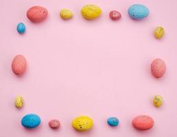 Frame with Easter eggs on a pink background, multi-colored eggs. - Copyspace photo