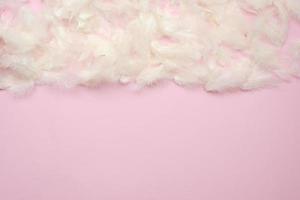 White feathers  lie on the half pink Easter background - Copyspace photo