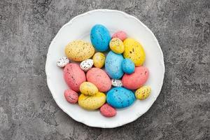 Colored easter eggs on plate on a gray plaster background. - Copyspace photo