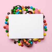 Empty template mockup white blank on a pink  Easter background. Multi-colored candy. - Copyspace photo